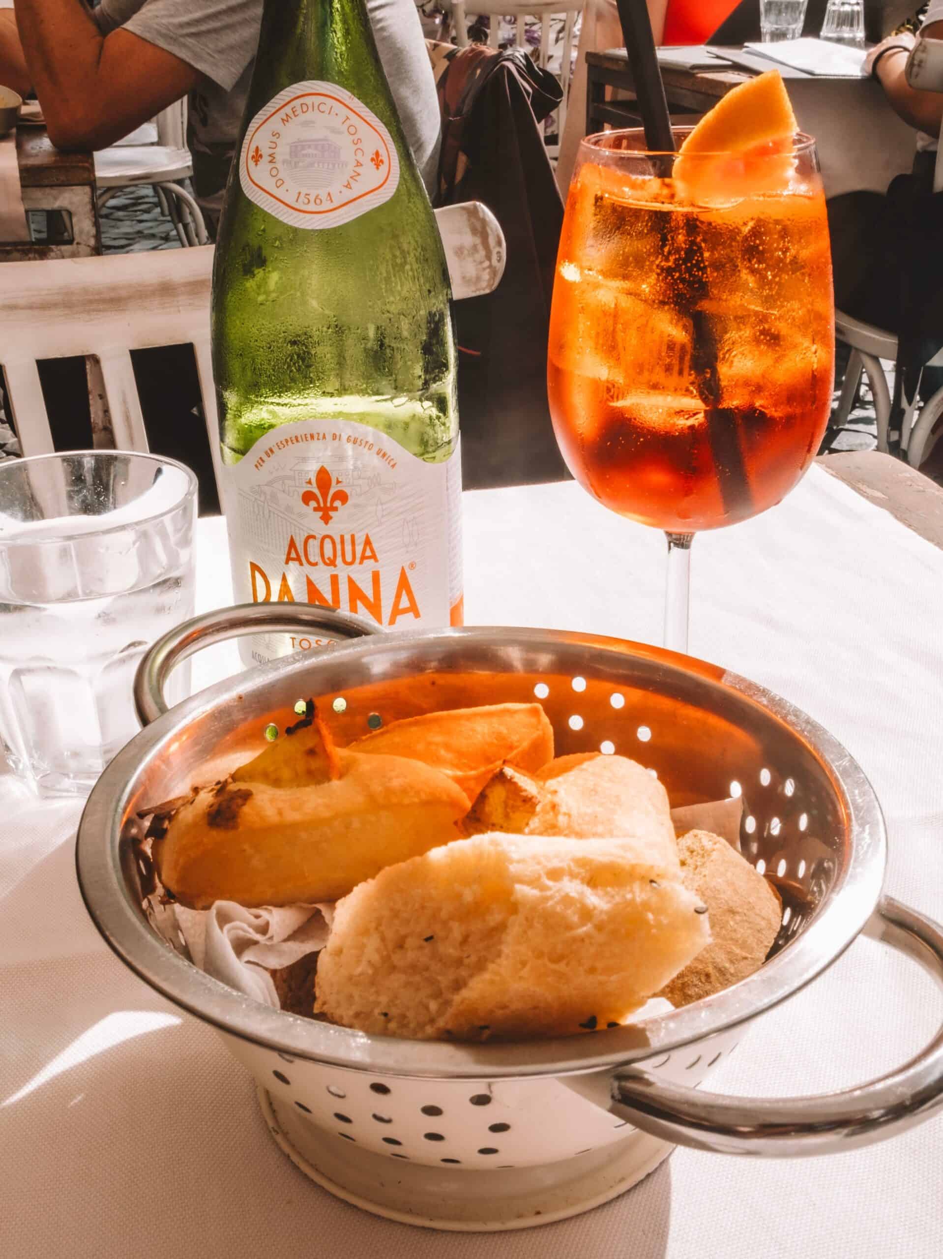 An Aperol Spritz and a basket of homemade bread from Ristorante La Scala in Trastevere. 