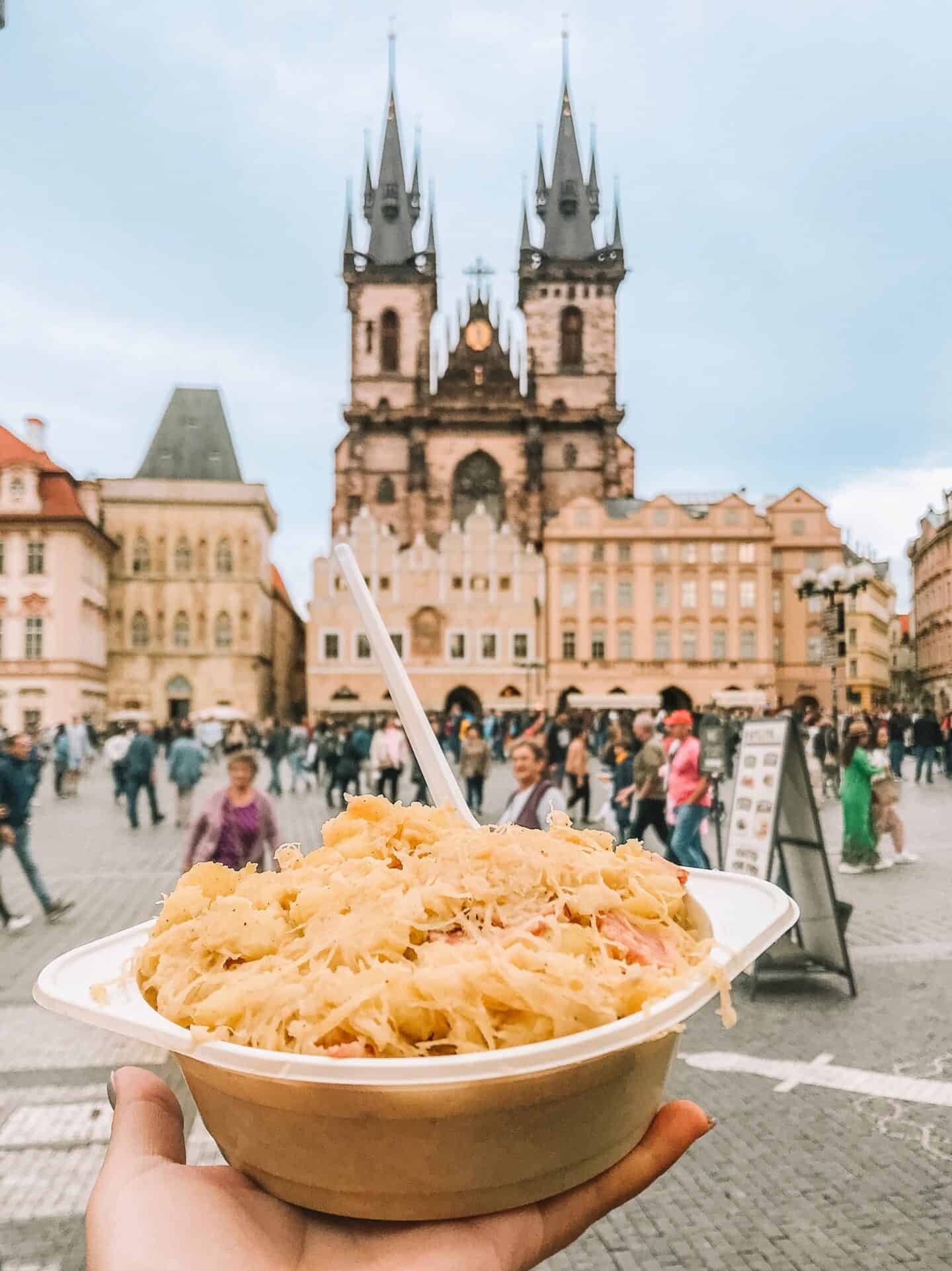 Eating a heaping bowl of halusky from a street vendor is a must-add to your 4 days in Prague itinerary