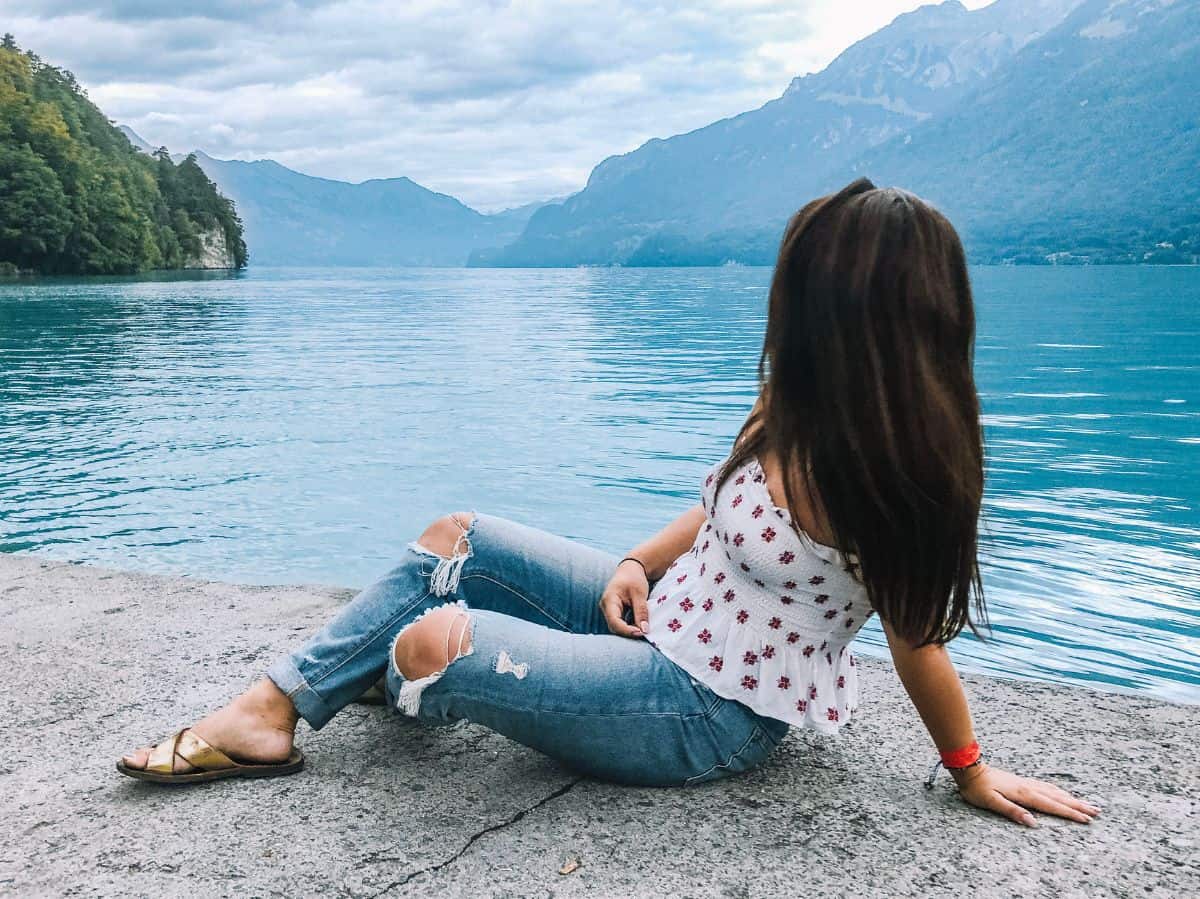 Me sitting on the water's edge and enjoying the views of Lake Brienz in Interlaken. 