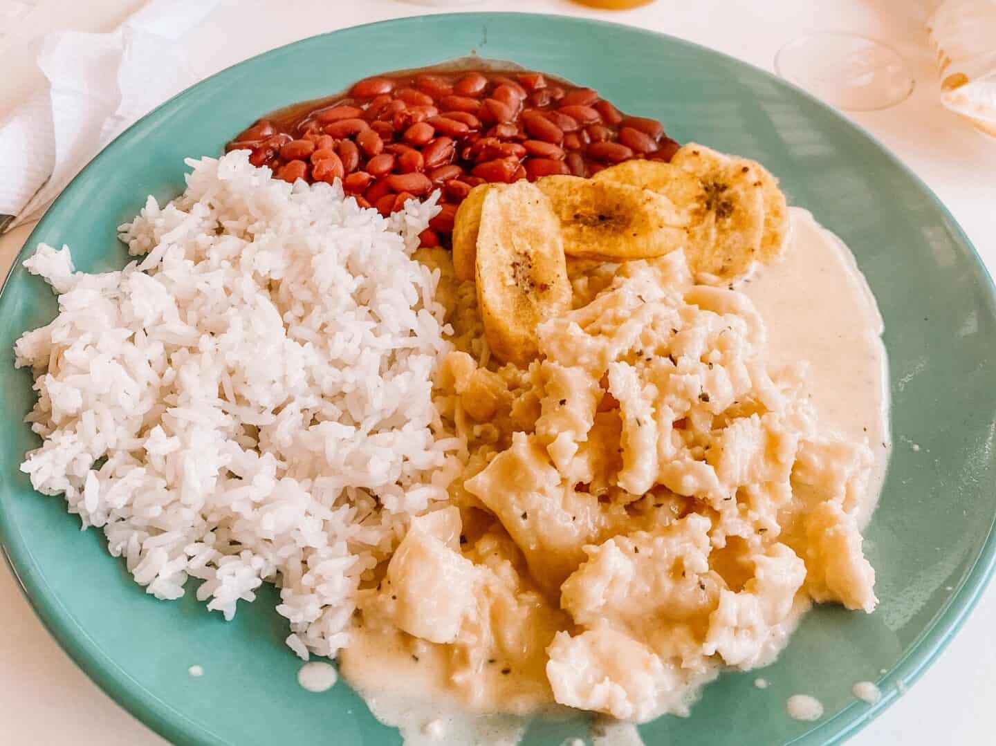 A heaping plate of conch in cream sauce, rice, beans and fried plantains from Loretta's Island Cooking Roatan