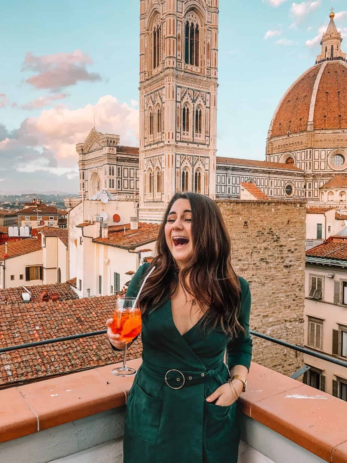 Laughing on a Florence rooftop bar with an Aperol Spritz and a view of the Duomo