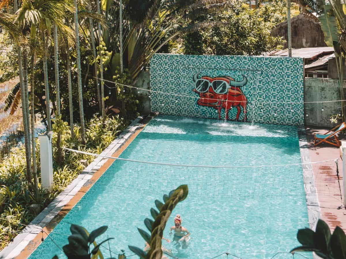 The outdoor pool surrounded by palm trees at the Mad Monkey Hostel in Hoi An Vietnam. 
