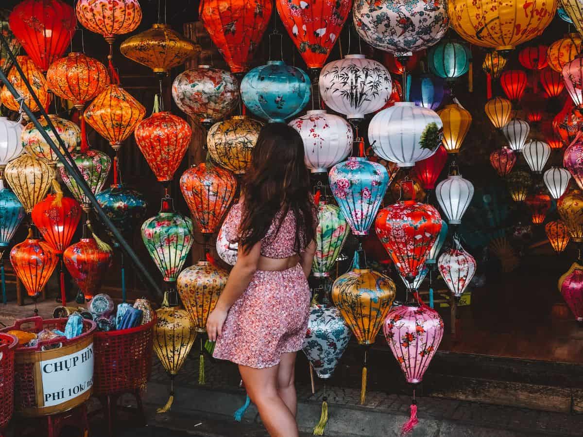 Me walking through the Nguyen Hoang Night Market and posing in front of a wall of colorful lanterns. 