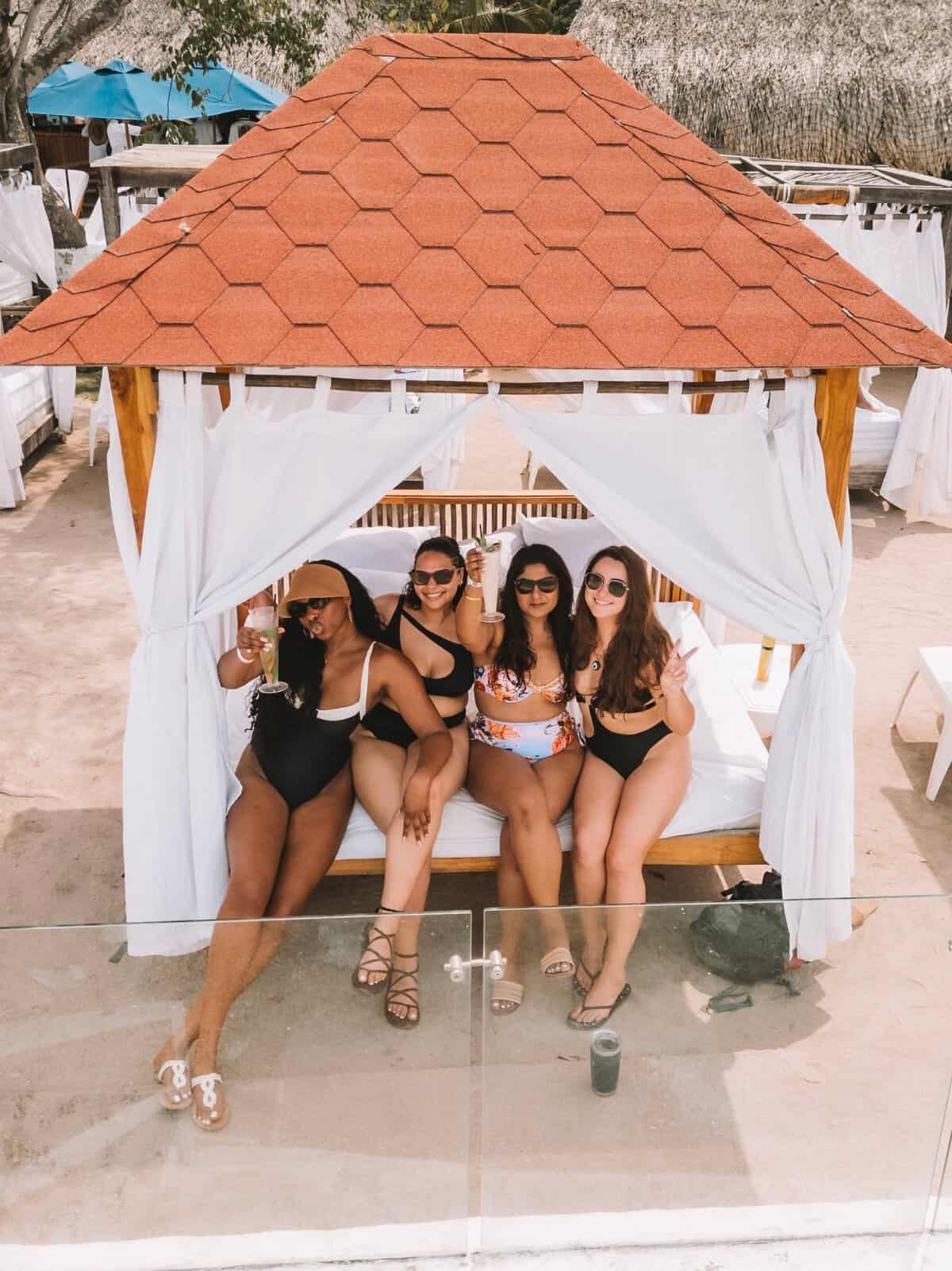 The four of us girls sitting in our day bed and smiling for the camera at Bora Bora Beach Club.