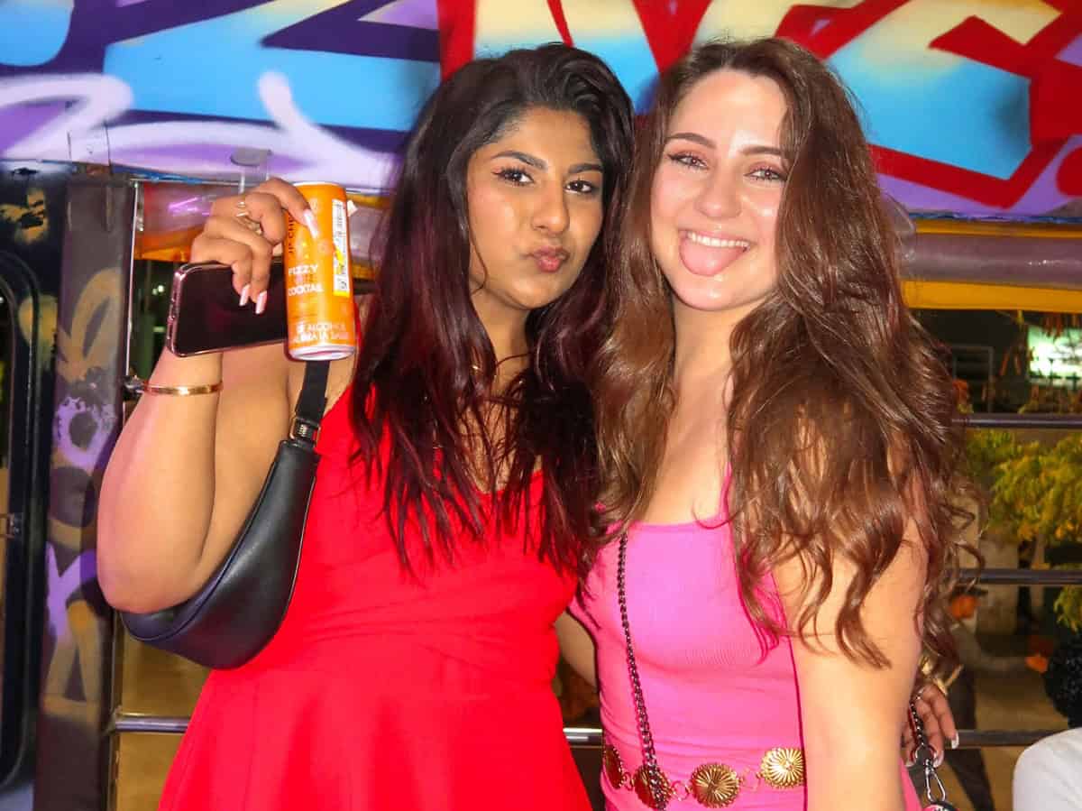 My friend and I in colorful dresses posing on the party bus while we cruise through the streets of Cartagena.